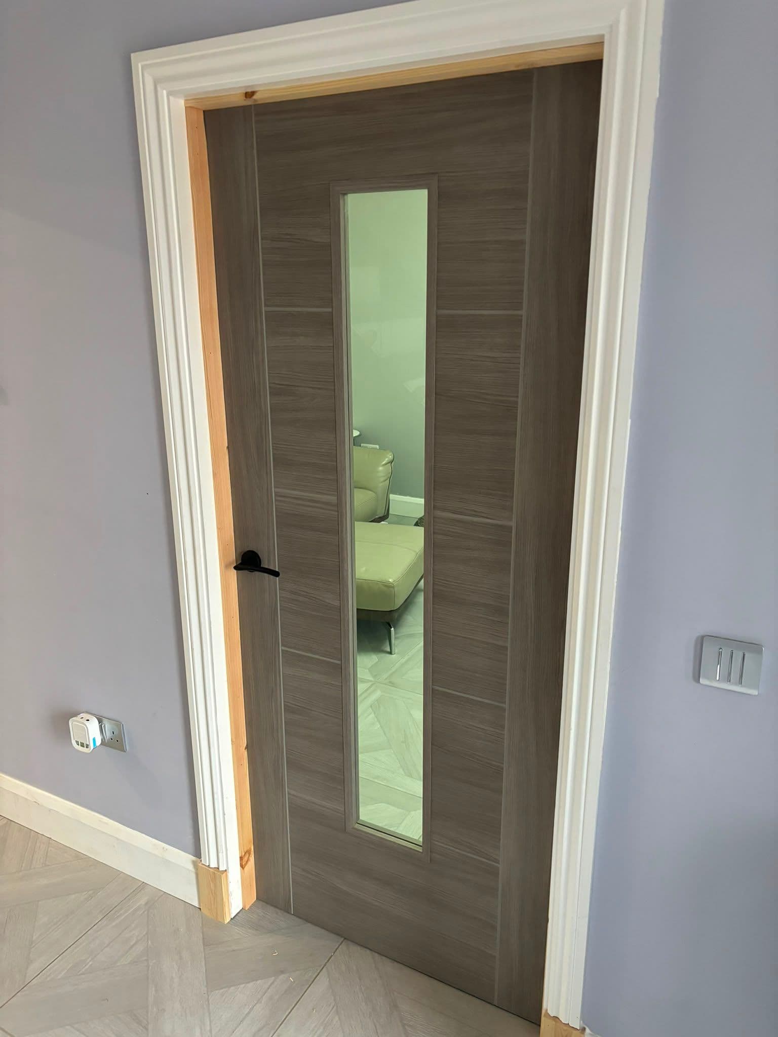 Glazed grey internal door with vision panel and black handle