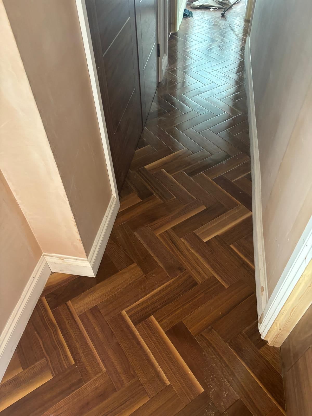 Dark walnut herringbone parquet flooring in a hallway