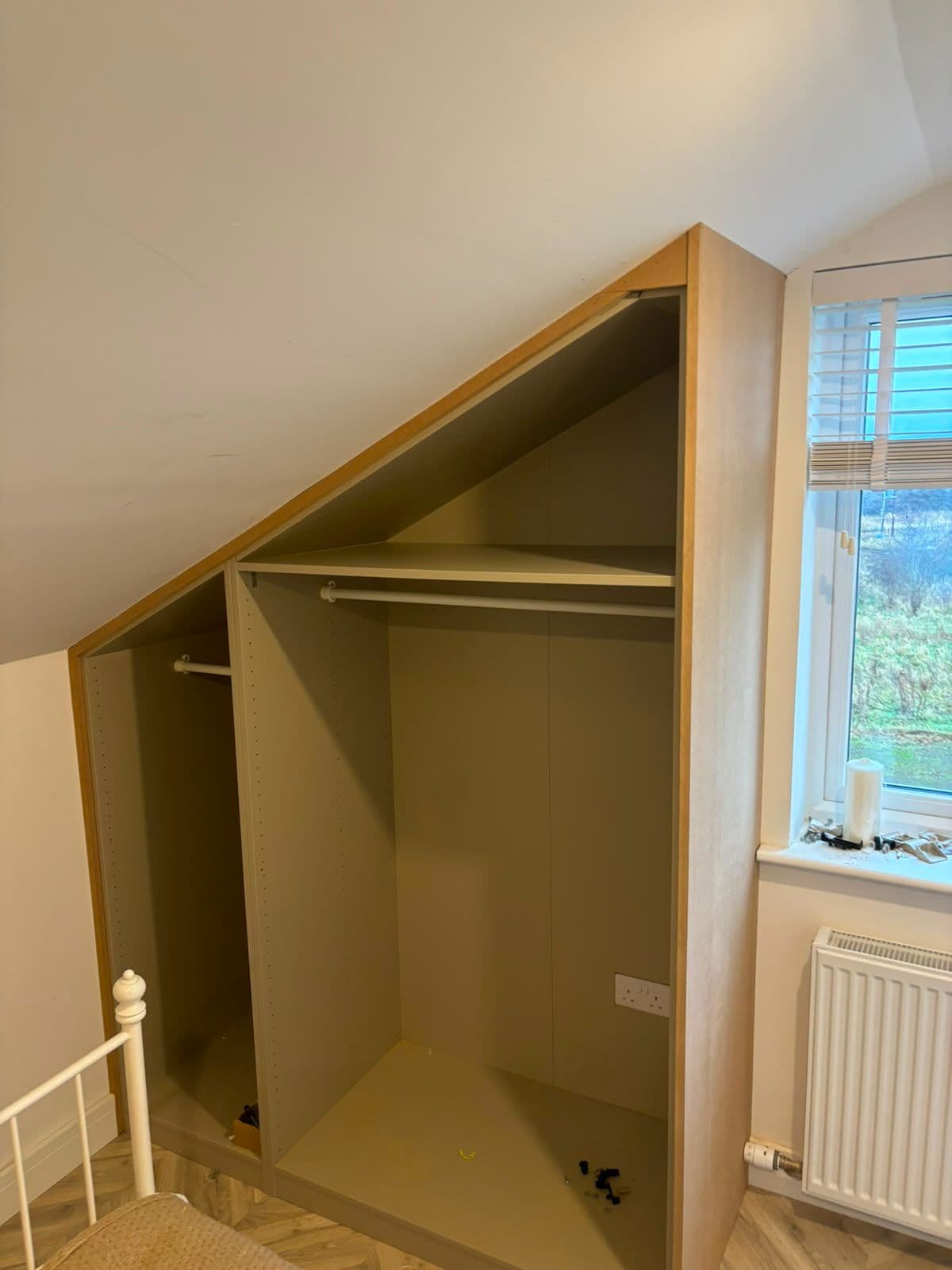 Bespoke fitted wardrobe built into a sloped attic ceiling